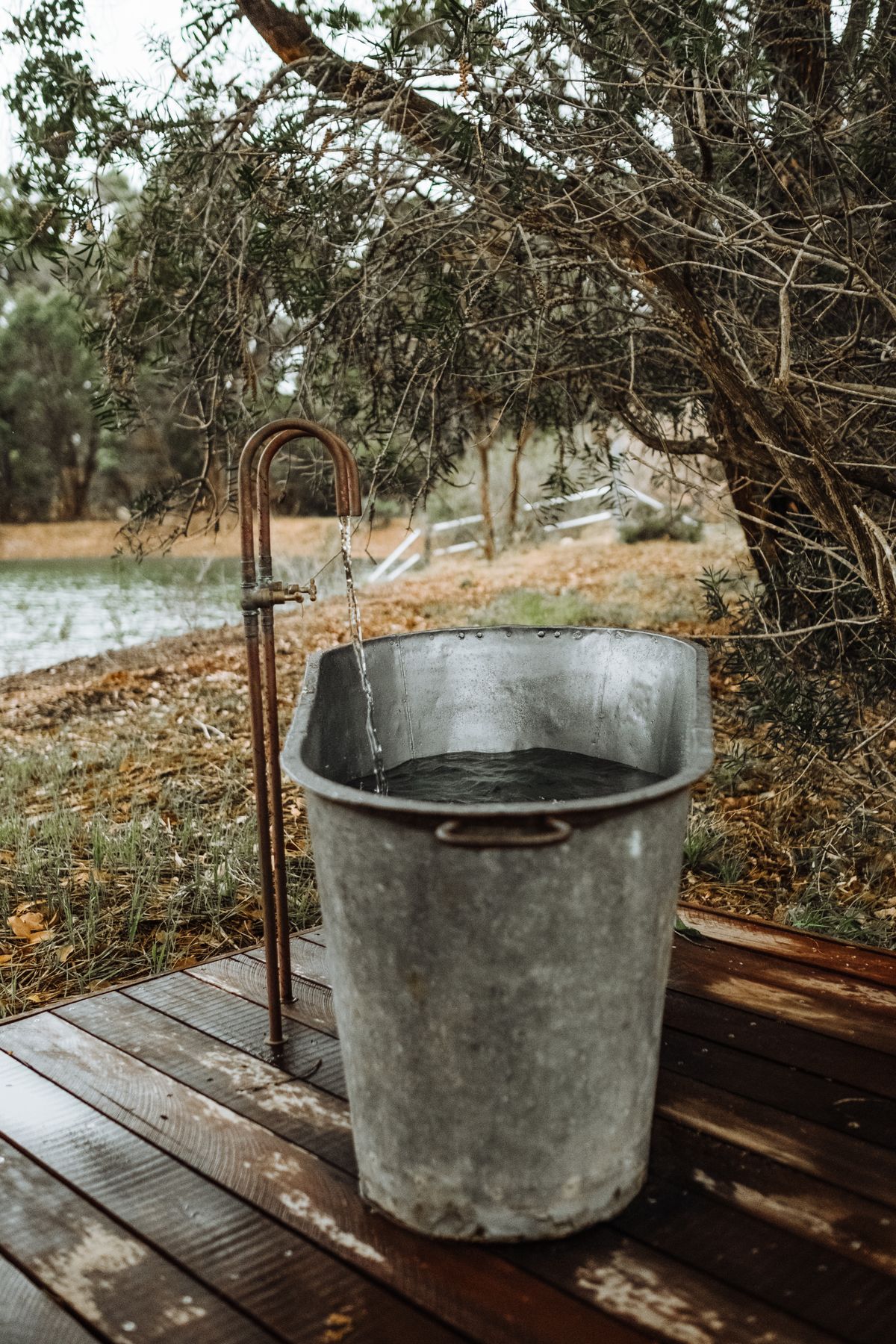 A backyard cold plunge tub being filled with cold water.