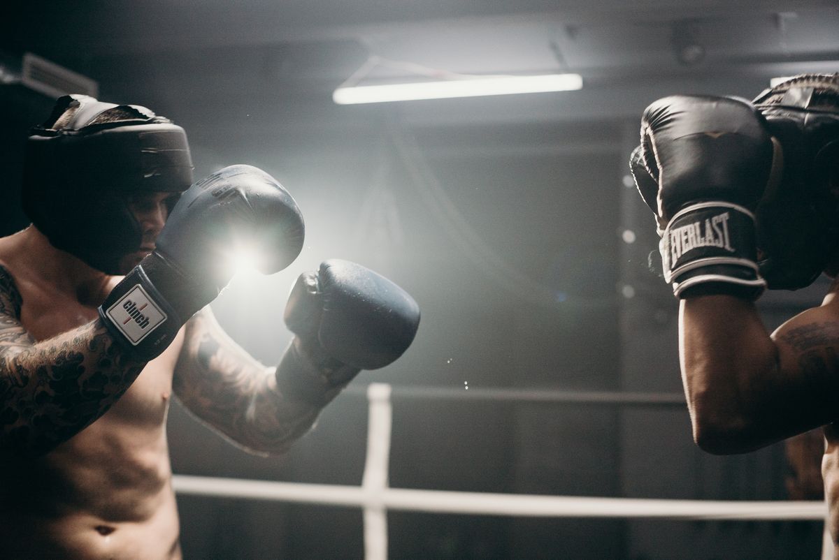Boxing gloves and a heavy bag in a gym.