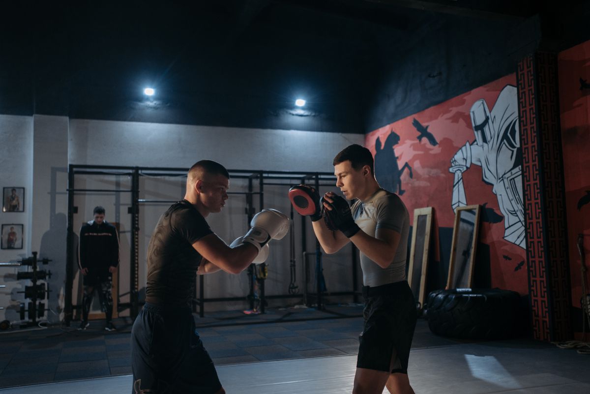 Two people training striking on the pads.