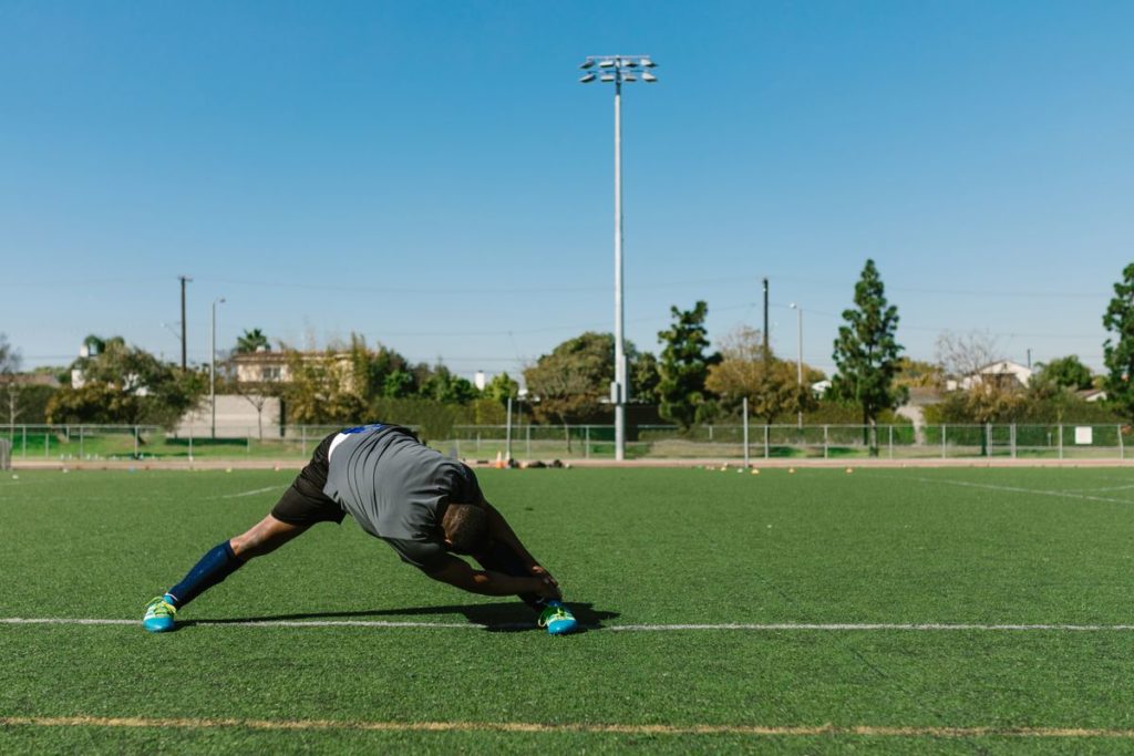 An athlete performing a deep lunge stretch as part of a warm up