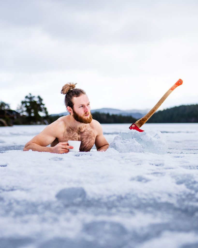 A person recovering in cold water surrounded by snow