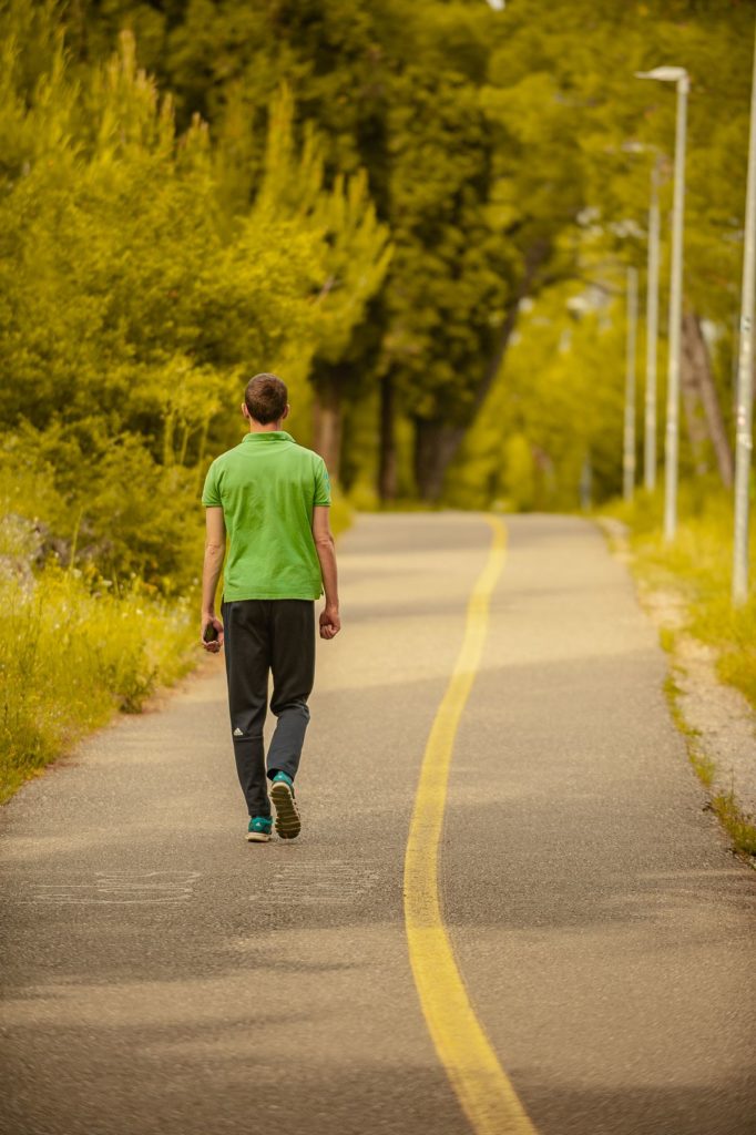 A runner on a tree lined open road
